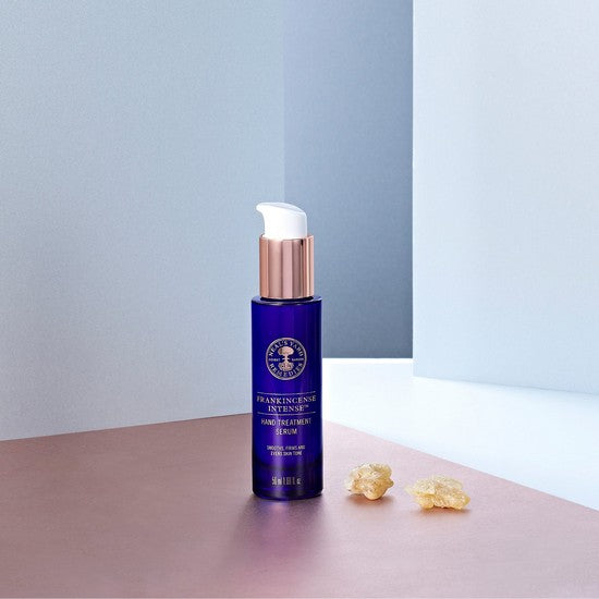 Frankincense Intense™ Hand Treatment Serum bottle on table 